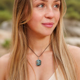 Ayana Crystals Chrysocolla pendant wrapped in copper on a vegan cord worn by a woman outdoors